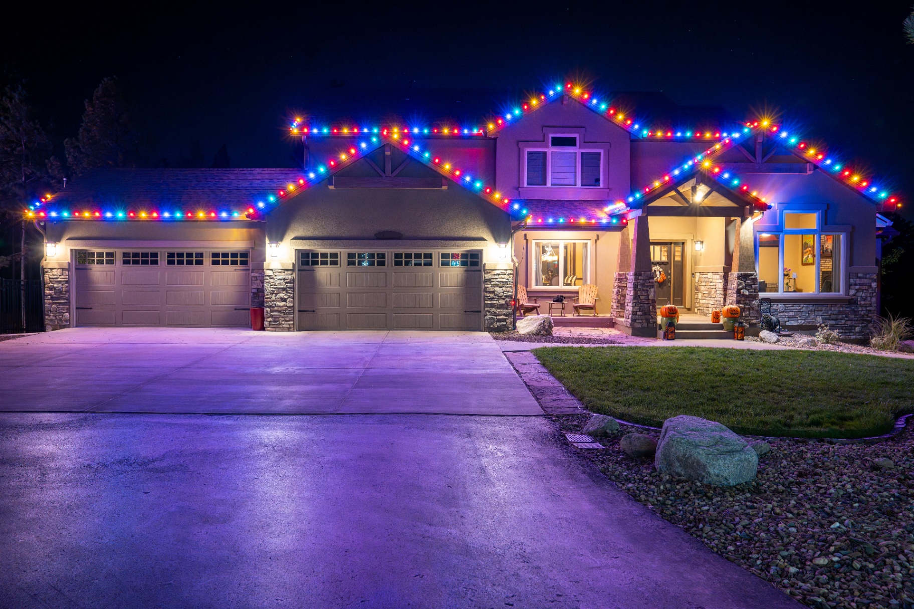 Vibrant blue, red, and orange Christmas lighting on a craftsman home