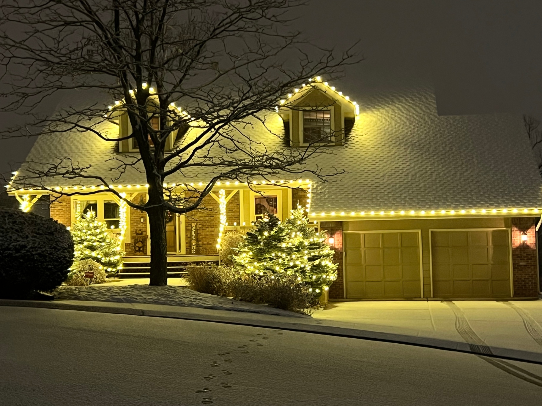 Warm white Christmas lighting on a snow-covered home
