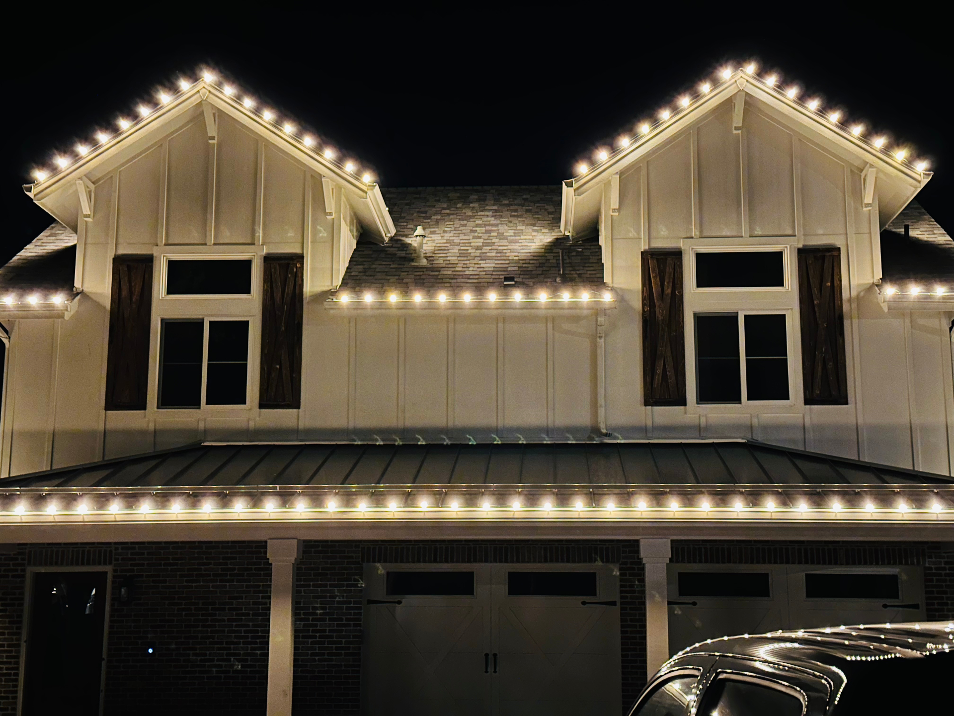 Warm white roofline lighting on a modern white home