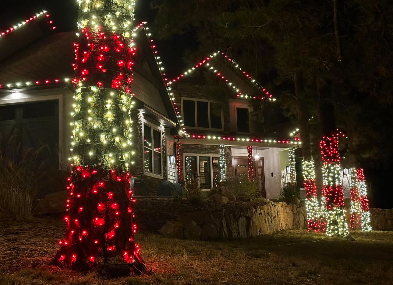 Red and white tree-wrapped lighting on a mountain home