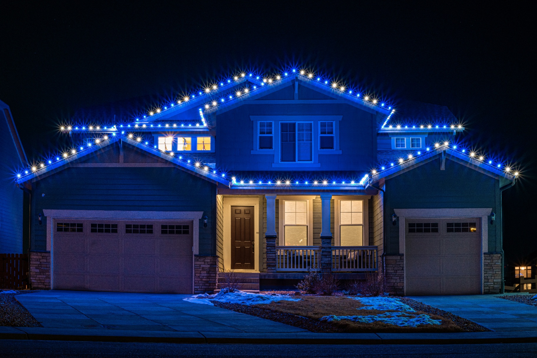 Blue and white Christmas lighting on a two-story home