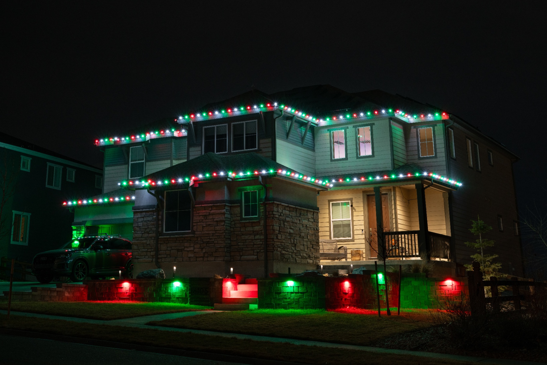 Red, white, and green Christmas lighting with ground spotlights