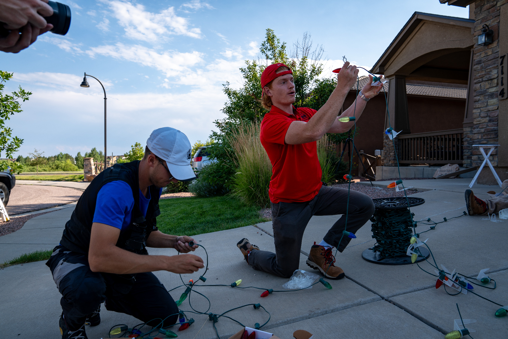 Reinforced Texas Lights installer hanging Christmas lights on a roofline
